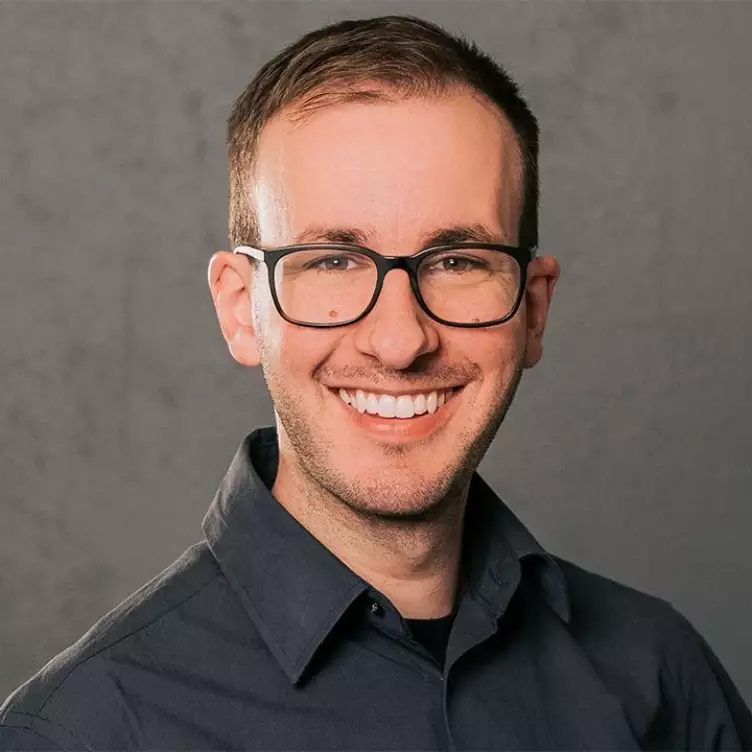 Eine Schülerklasse im Klassenzimmer vor aufgeschlagenem Lehrbuch