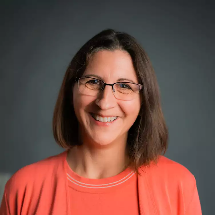 Eine Schülerklasse im Klassenzimmer vor aufgeschlagenem Lehrbuch