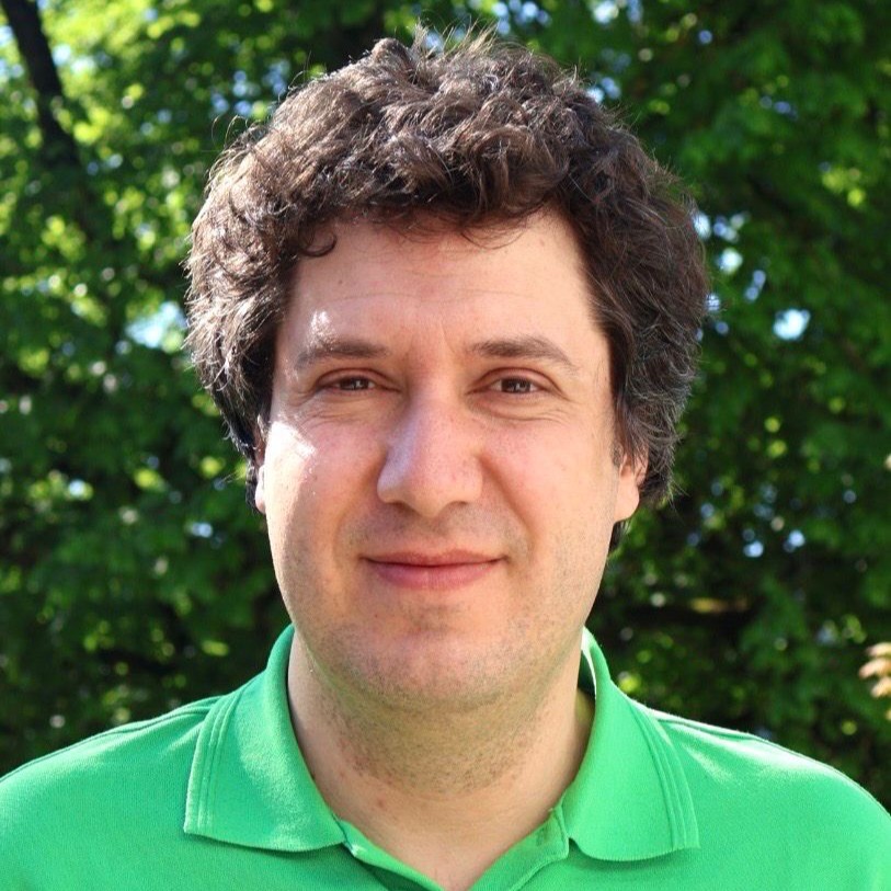 Eine Schülerklasse im Klassenzimmer vor aufgeschlagenem Lehrbuch