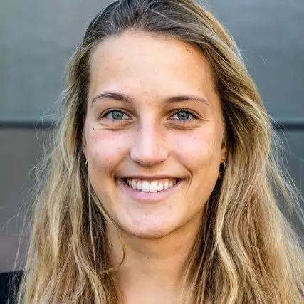 Eine Schülerklasse im Klassenzimmer vor aufgeschlagenem Lehrbuch