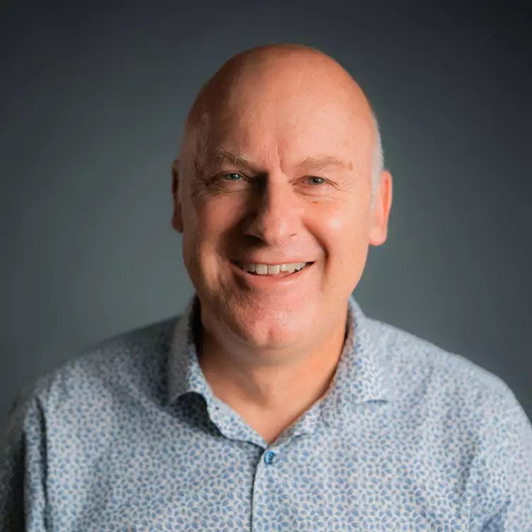 Eine Schülerklasse im Klassenzimmer vor aufgeschlagenem Lehrbuch